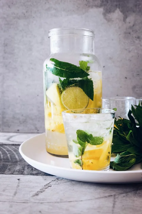 Limonada com gelo, rodelas de limão e folhas de hortelã.